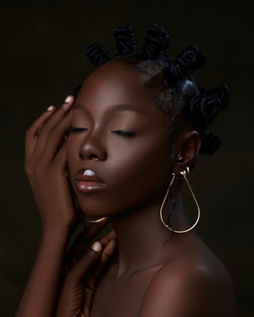 Captivating portrait of a woman with elegant bun hairstyles and artistic earrings.